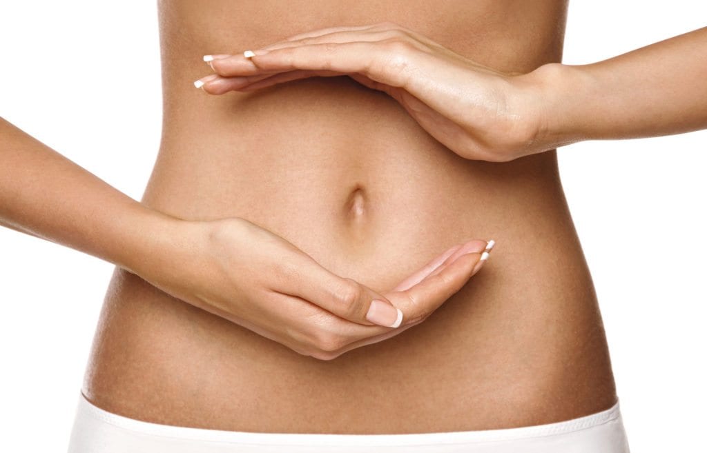 woman's bare stomach with hands circled around naval