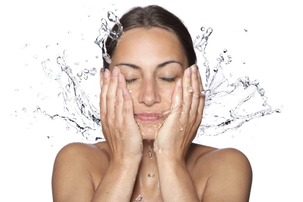 Woman splashing water on face