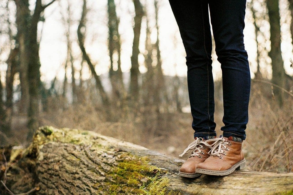 woman standing on tree log