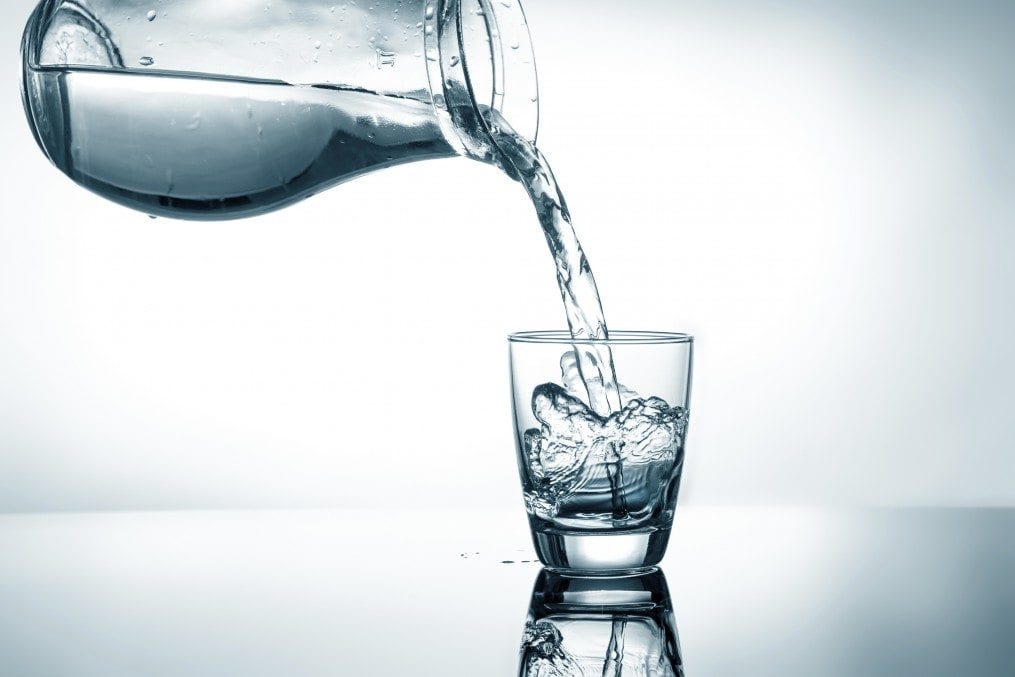 pitcher pouring water into cup