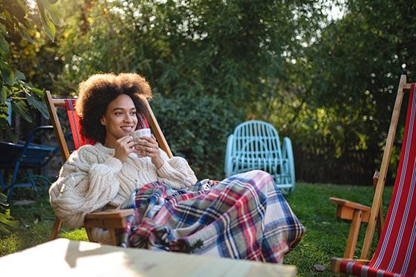 Happy woman sitting in a chair outside