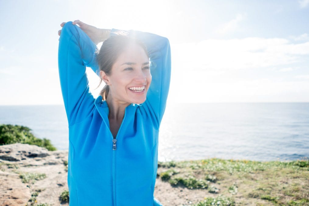 Happy woman stretching before exercise