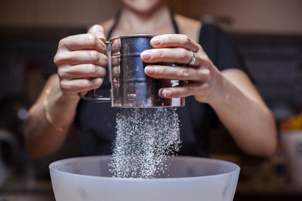 woman sifting flour for baking
