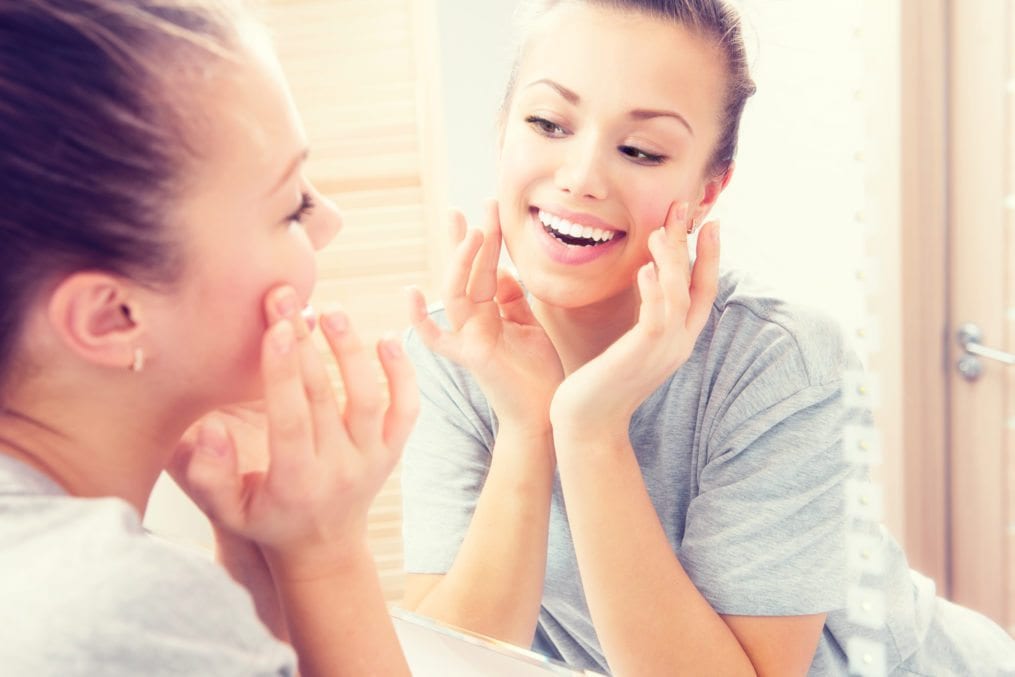 Teenager admiring skin in mirror