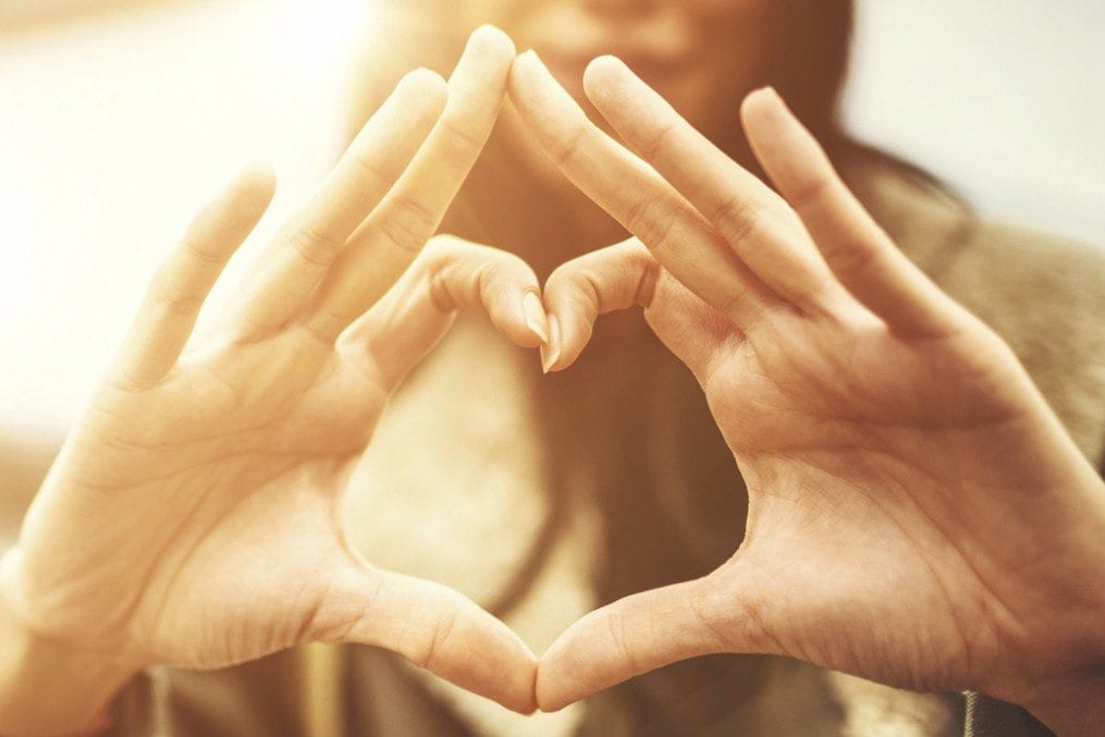 woman making heart shape with hands