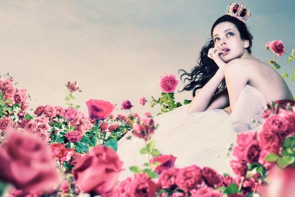 woman sat on field of flowers