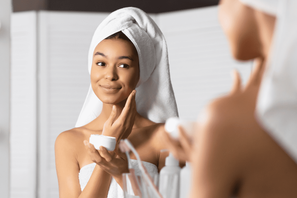 winter skincare - woman applying cream on face